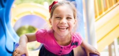 Young girl laughing on outdoor playground