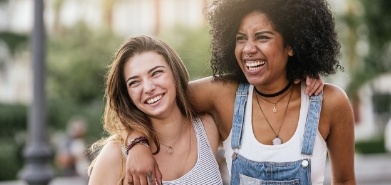 Two young women laughing together outdoors