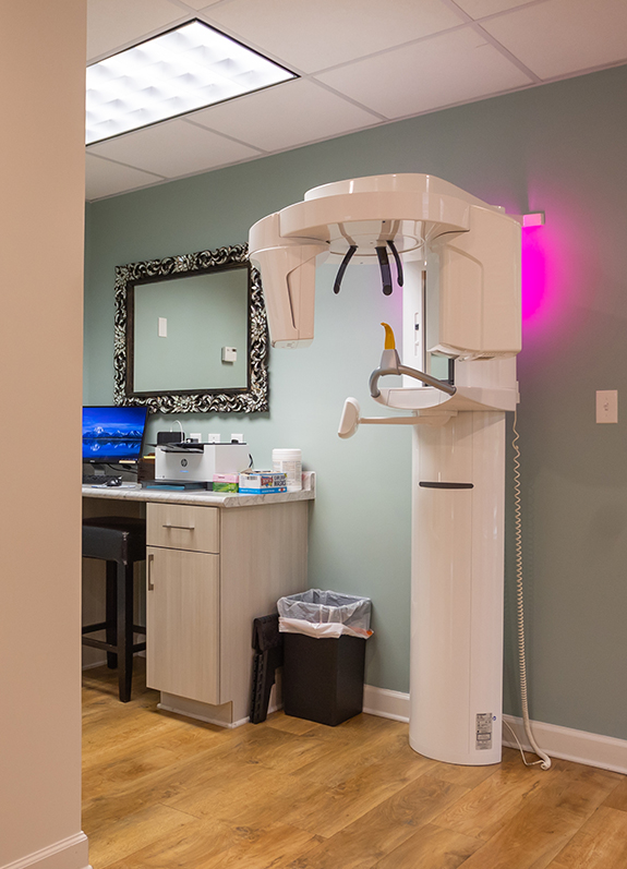 C T cone beam scanner standing against white wall