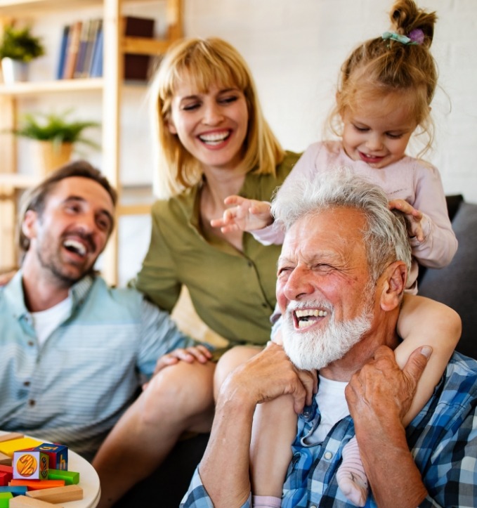 Three generations of family laughing together in living room