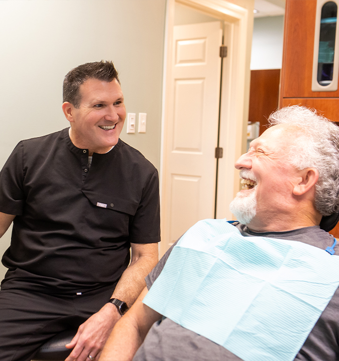 Jonesboro Arkansas dentist Doctor Joseph S Spades smiling at young woman in dental chair