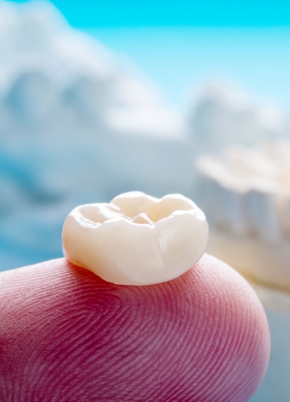 Dental crown resting on a finger